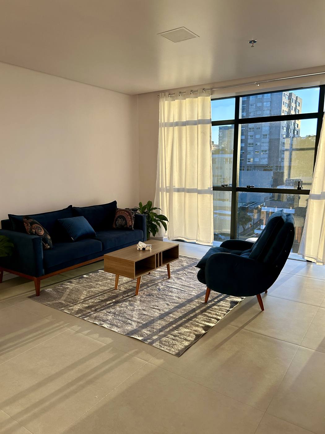 Consultório da Aline Santin, com poltronas em tom azul-marinho e luz natural